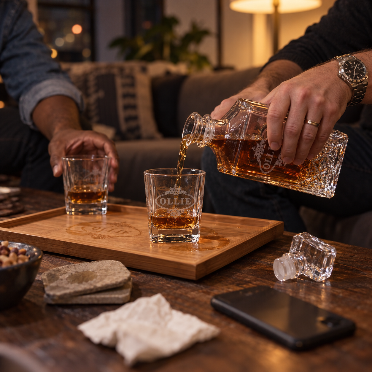A man pours the first glass from his engraved Serve It Up decanter at home, the second glass and the bamboo tray beside it