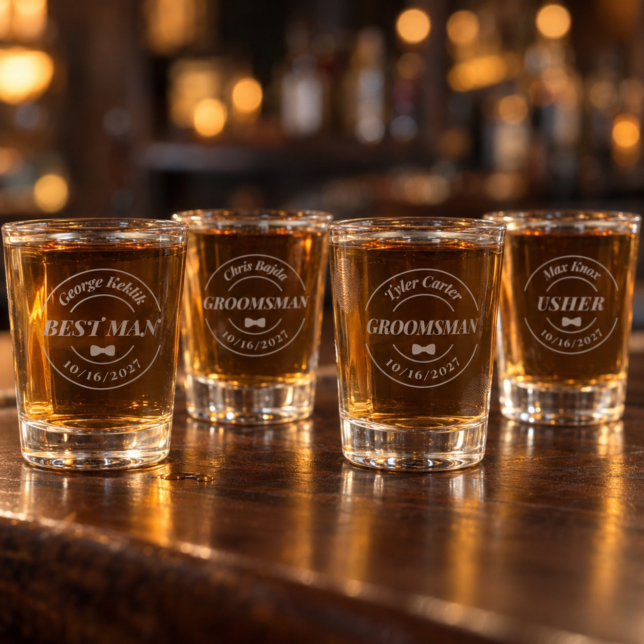 Four groomsmen shot glasses for the wedding party, each badge engraved with a name and role: Best Man, two Groomsmen and an Usher