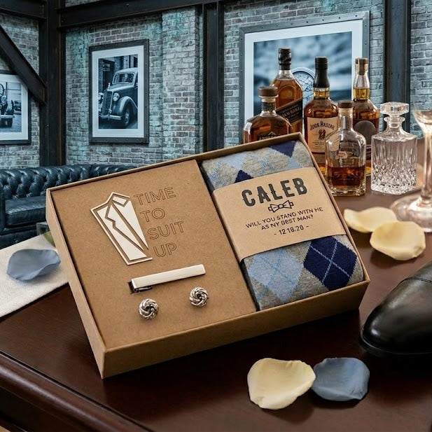 Groomsmen proposal gift set with socks, cufflinks, and tie bar on a wooden table.