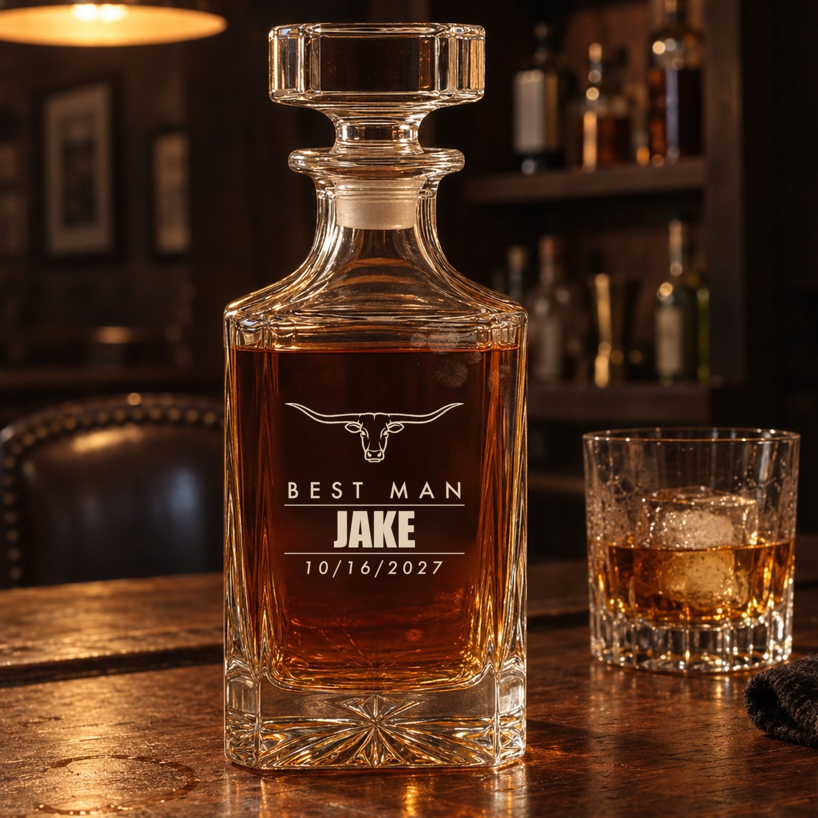Personalized groomsmen whiskey decanter on a home bar, engraved with a longhorn, Best Man, the name Jake and the wedding date 10/16/2027