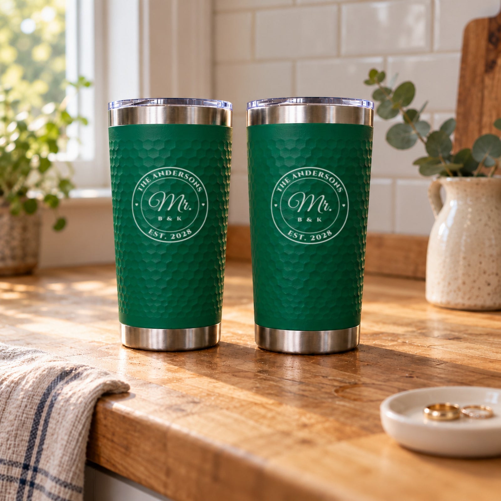 Mr. and Mr. wedding gift for two grooms: matching green engraved tumblers for The Andersons, Est. 2028, on a sunlit butcher block