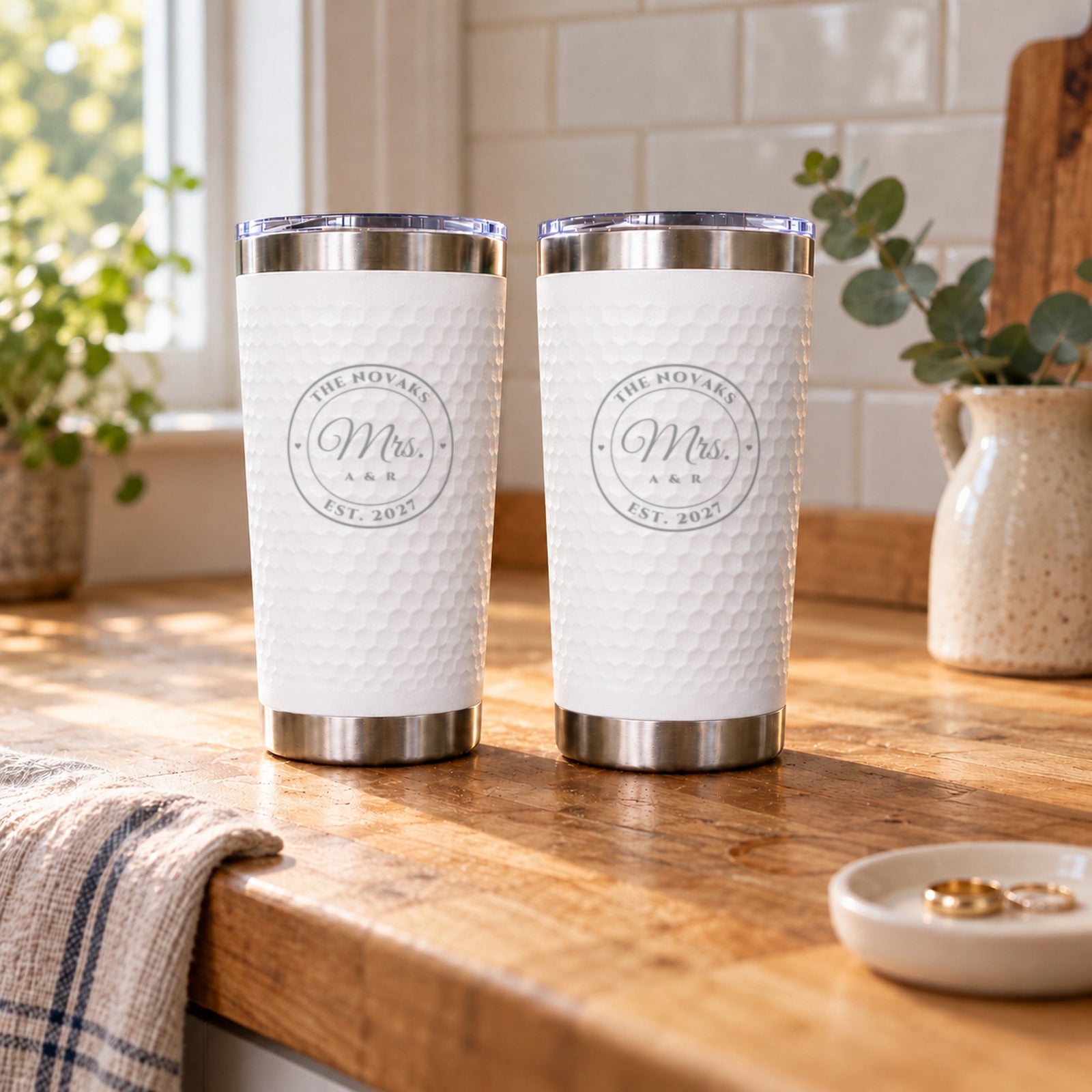 Mrs. and Mrs. wedding gift for two brides: a pair of white engraved tumblers for The Novaks, Est. 2027, side by side on a kitchen counter