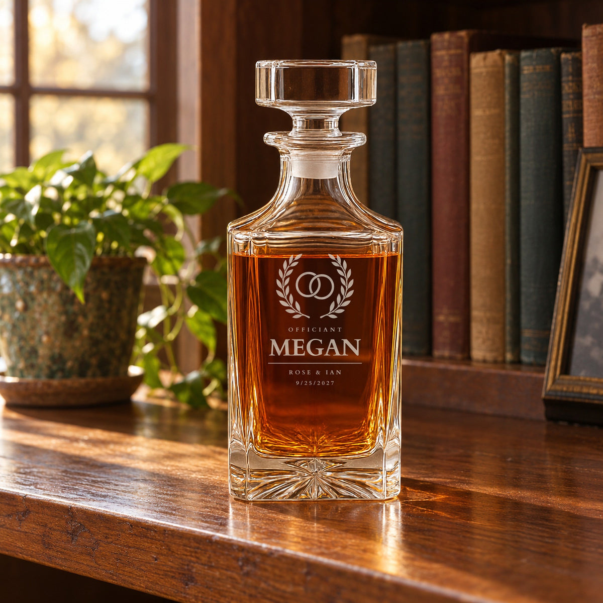 Officiant gift on a home bookshelf after the wedding, a whiskey decanter engraved Megan with the couple's names Rose and Ian and the wedding date 9/25/2027