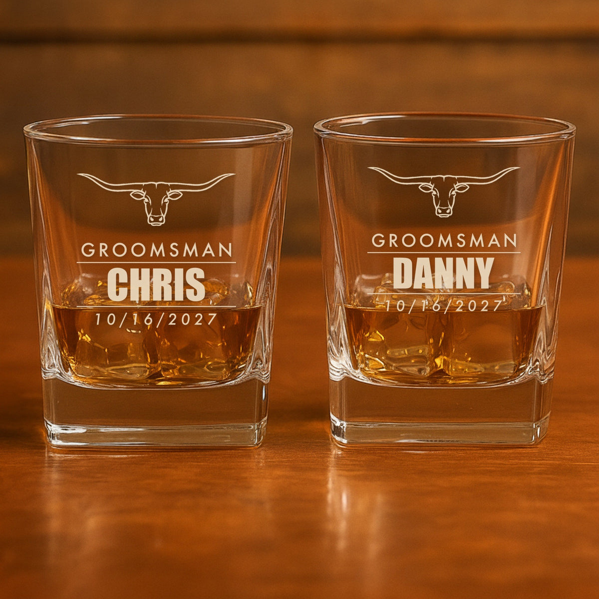 Two personalized groomsmen whiskey glasses on a bar, engraved Groomsman Chris and Groomsman Danny with the wedding date 10/16/2027