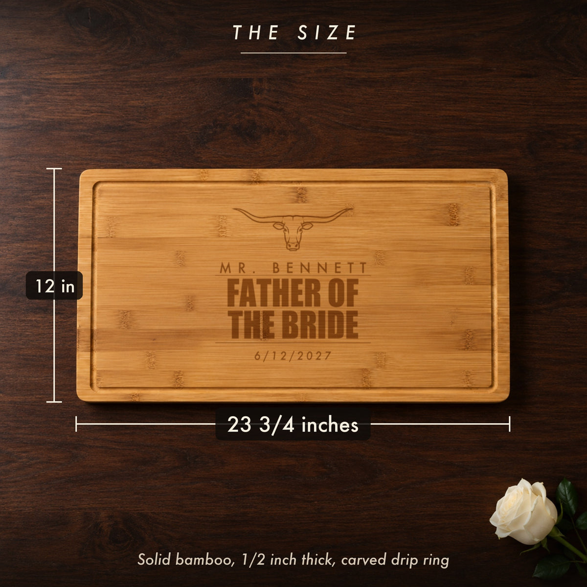 Size of the father of the bride cutting board, 23 3/4 inches long by 12 inches wide in half inch solid bamboo, shown on a dark walnut table