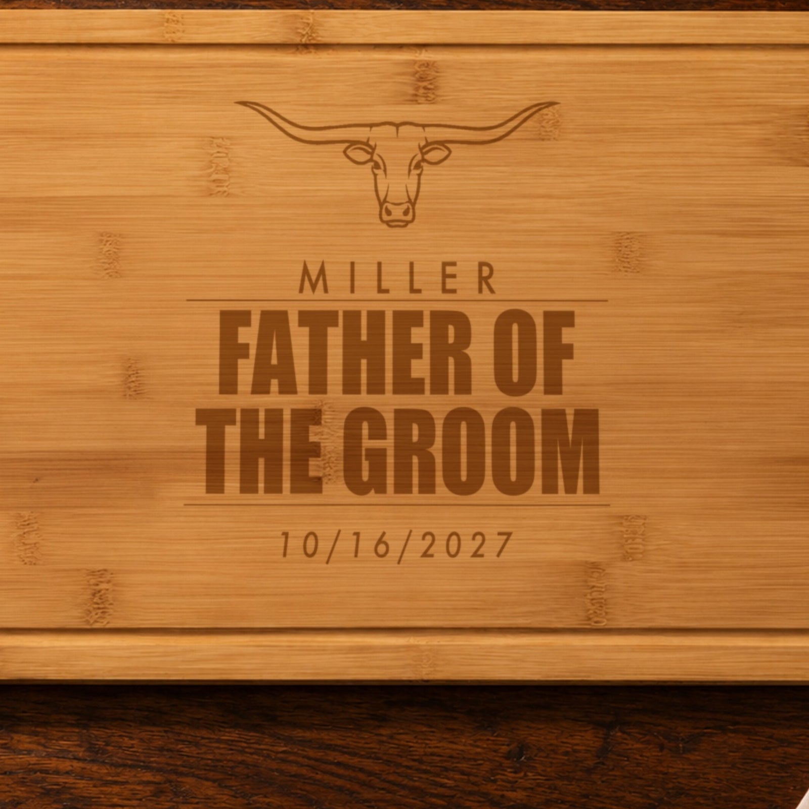 Close-up of the laser engraving on the father of the groom cutting board: the longhorn steer, MILLER and FATHER OF THE GROOM burned into the bamboo