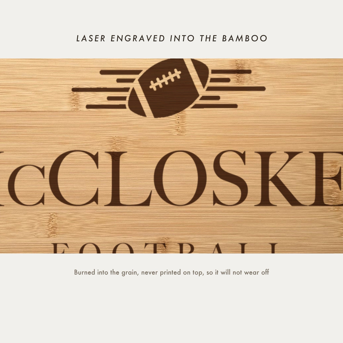 Close view of the football with speed lines laser engraved into the bamboo grain above the family name in a high contrast serif.