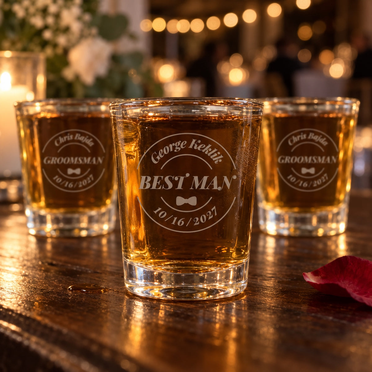 Personalized groomsmen shot glasses on a reception bar, the front glass engraved George Keklik, Best Man and 10/16/2027 in a round badge