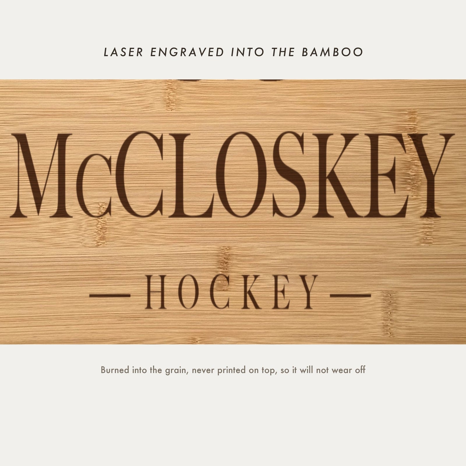 Close view of the family name and the word Hockey laser engraved into the bamboo grain in spaced serif capitals between two fine rules.
