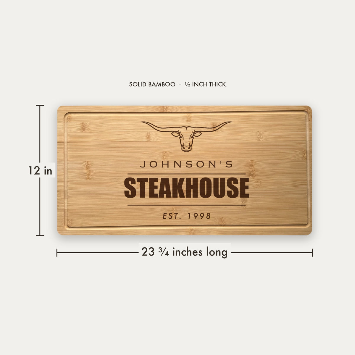Size guide for the personalized steakhouse cutting board, 23 and three quarter inches long by 12 inches wide in half inch thick solid bamboo.