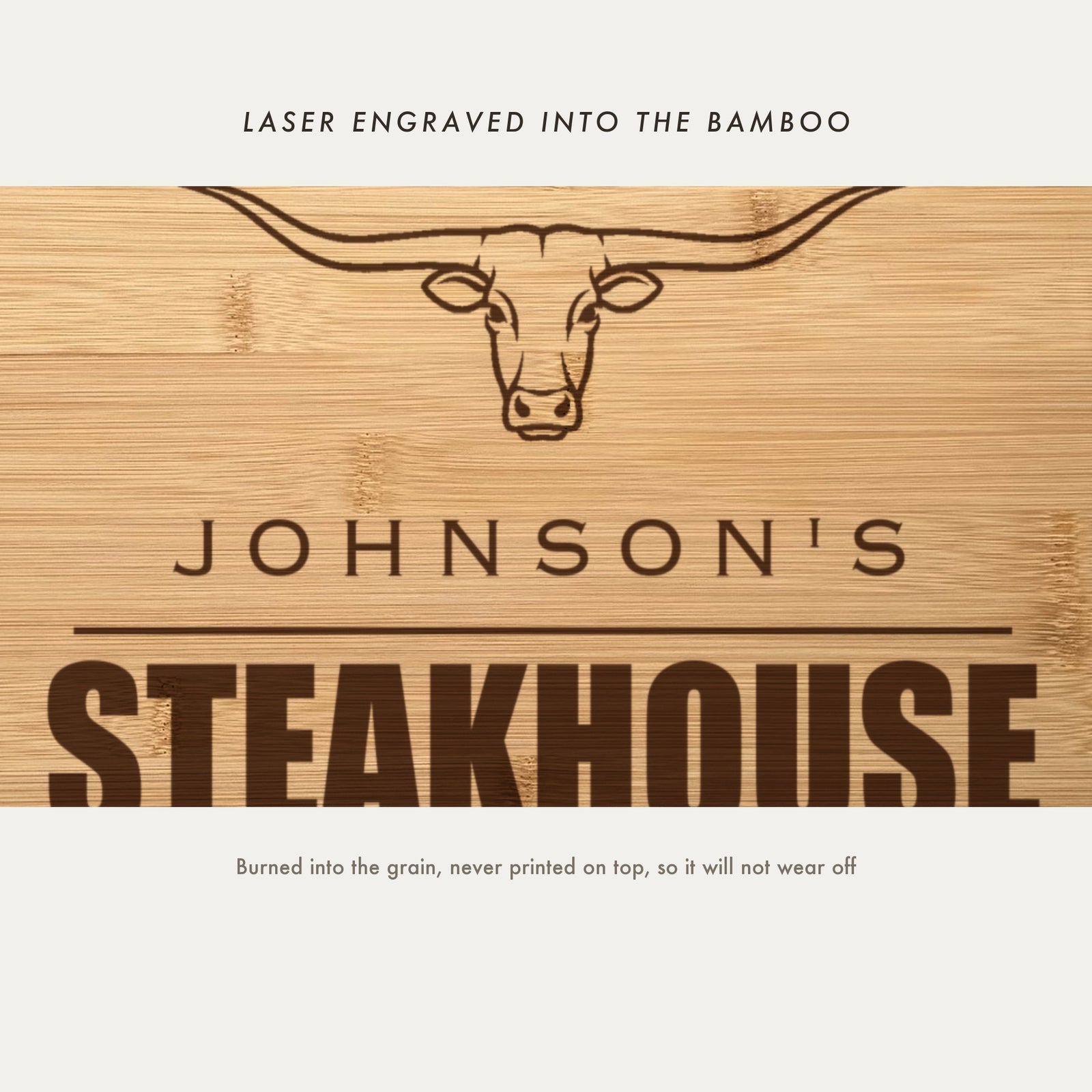 Close view of the longhorn steer and the word Steakhouse laser engraved into the bamboo grain in heavy block capitals between two rules.