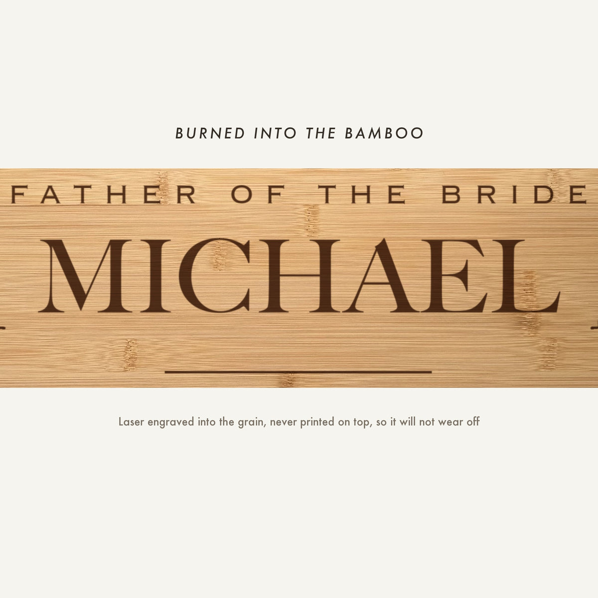 Close view of Father of the Bride and the name Michael laser engraved into the bamboo grain in spaced capitals above a fine horizontal rule.