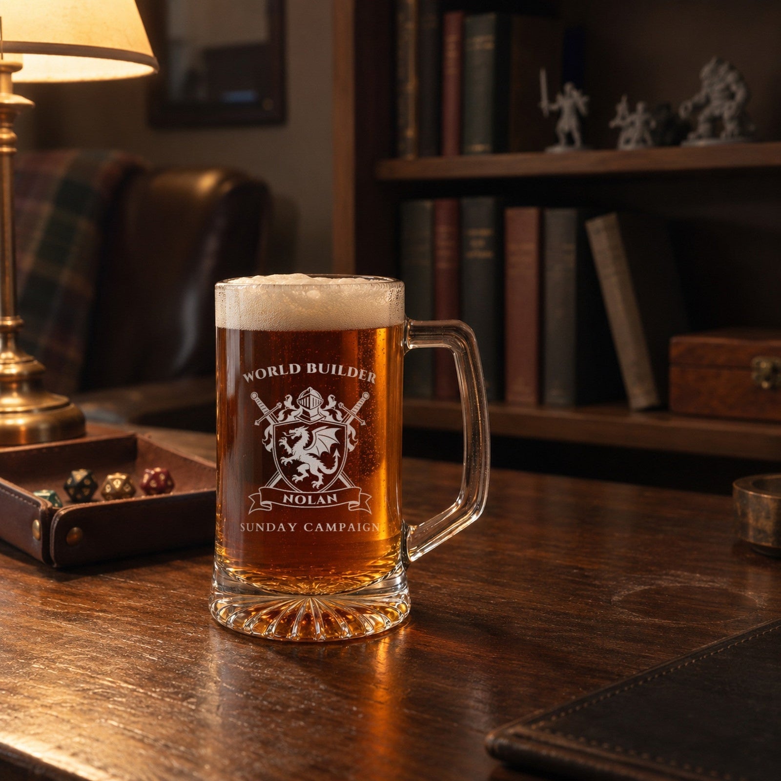 Engraved gamer groomsmen beer mug on a walnut desk in a game room with miniatures and a dice tray, reading WORLD BUILDER, NOLAN and SUNDAY CAMPAIGN
