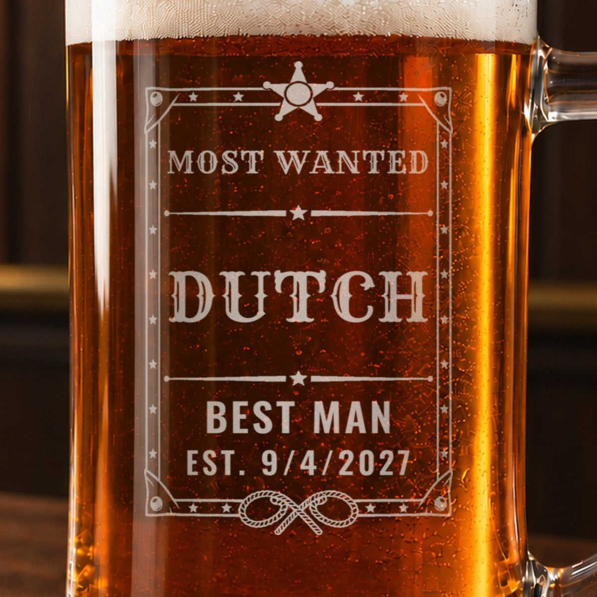 Close-up of the frosted engraving on the wanted poster beer stein, an Old West wanted poster with a sheriff star and lassos: Most Wanted, Dutch, Best Man, Est. 9/4/2027
