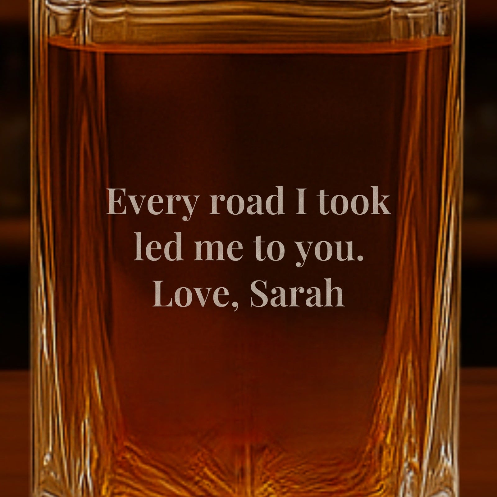 Close-up of a note from the bride engraved on the back of a whiskey decanter for the groom: Every road I took led me to you, signed Love, Sarah