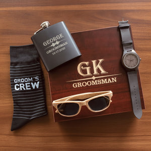 Personalized groomsmen gift set with engraved cherry keepsake box, matte black flask, Groom's Crew socks, wood grain sunglasses and sandalwood watch